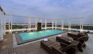 - Balcón con piscina en un edificio en Quality Inn Gurgaon, en Gurgaon