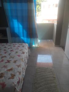 um quarto com uma cama, uma janela e um piso de azulejo em Hostel e Pousada Maria Bonita em Paripueira