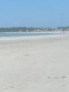 a beach with people walking on the sand at Hostel e Pousada Maria Bonita in Paripueira