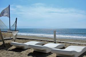 two white lounge chairs on a beach with the ocean at Estudio 573 Nuevo Vallarta, frente al mar, equipado y amueblado ! in Nuevo Vallarta 