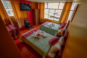 a bedroom with two beds and a table with towels at Yacumama Santa Teresa in Santa Teresa