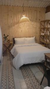 Un dormitorio con una gran cama blanca y una lámpara de araña. en Tuku,, en Guarinocito