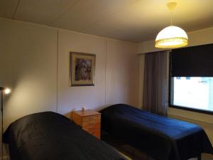 ein Hotelzimmer mit 2 Betten und einem Fenster in der Unterkunft Holiday House Mäntyniemi in Hossa