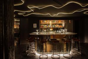 a bar with stools in front of a counter with drinks at The Robey, Chicago, a Member of Design Hotels in Chicago