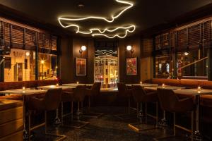 a restaurant with tables and chairs and a neon sign at The Robey, Chicago, a Member of Design Hotels in Chicago