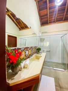 Baño con 2 lavabos y flores rojas en una encimera en Go Organic Club - Santo Antônio do Pinhal SP, Brasil, en Santo Antônio do Pinhal