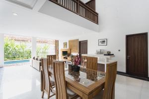 a kitchen and dining room with a glass table and chairs at Delu Villas & Suite in Kerobokan