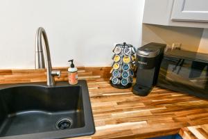 eine Küchentheke mit einer Spüle und einer Mikrowelle in der Unterkunft The Darmont Hotel and Suites in Darby
