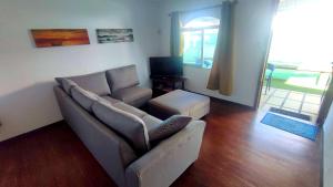 a living room with a couch and a television at Villa Rose in Pereybere