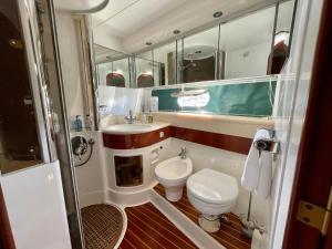 a bathroom with a toilet and a sink and mirror at Tranquility Yachts -a 52ft Motor Yacht with waterfront views over Plymouth. in Plymouth