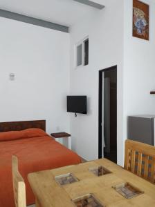een slaapkamer met een bed, een tafel en een televisie bij Gal - Habitaciones Confortables in Cuernavaca