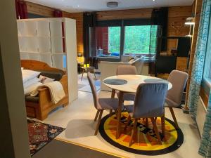 a room with a table and chairs and a bedroom at Katiskosken joenrantamökki in Hämeenlinna