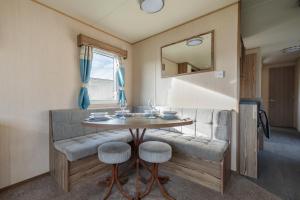 een eetkamer met een tafel en stoelen en een spiegel bij Waterside, Thorpe Park Cleethorpes Static Caravan in Cleethorpes