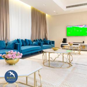 Byblos Villa Resort في الحد: غرفة معيشة مع أريكة زرقاء وتلفزيون