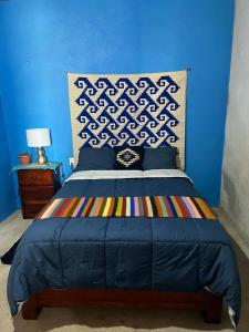 a blue bedroom with a bed and a blue wall at LÍZU Tu casa en un pueblo zapoteca in Teotitlán del Valle