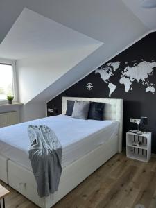 um quarto com uma grande cama branca e uma parede preta em Schicke Wohnung in Stadtnähe em Wurtzburgo