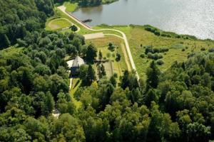 an aerial view of a house on a hill next to a lake at Natura Park in Połczyn-Zdrój