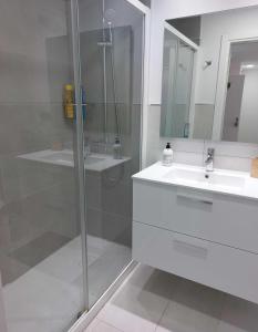 baño blanco con ducha y lavamanos en Apartamento Nuevo en Playa del Águila Maspalomas, en San Bartolomé