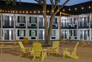 un grupo de sillas y mesas frente a un edificio en Atrea Inn Amarillo en Amarillo