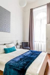 een slaapkamer met een groot bed met een blauwe deken erop bij Goldsmith Apartment in Boedapest