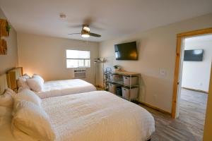 a bedroom with two beds and a flat screen tv at The Darmont Hotel and Suites in Darby