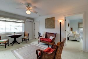 een woonkamer met een plafondventilator, stoelen en een tafel bij Lovely 2 bedroom condo in the heart of Flagler in Flagler Beach