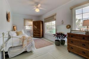 een slaapkamer met een bed, een dressoir en ramen bij Lovely 2 bedroom condo in the heart of Flagler in Flagler Beach