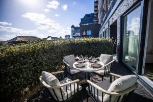 a patio with a table and chairs on a balcony at The Lagune, light and sunny apartment in the dunes in Cadzand