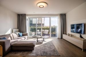 a living room with a couch and a table at The Lagune, light and sunny apartment in the dunes in Cadzand