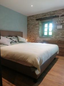 a bedroom with a large bed and a window at La Maison de Madeleine in Léglise