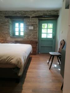 a bedroom with a bed and a green door at La Maison de Madeleine in Léglise