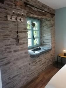um quarto com uma parede de pedra e uma janela em La Maison de Madeleine em Léglise
