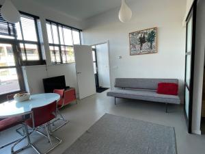 una sala de estar con un sofá y una mesa en Studio 28A5 with free parking place, en Ámsterdam