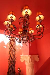 a chandelier hanging from a red wall with a column at A Fei Surf Inn III in Nanwan