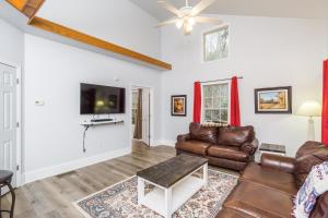 a living room with leather furniture and a flat screen tv at New Listing! Bavarian Cabin - 2 Bedrooms, 8 Minutes to Dahlonega, Hot Tub, Game Room in Dahlonega