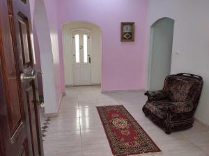 a room with a chair and a door with a rug at Best appartment in Quseir