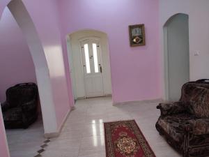 a room with a door and two chairs and a rug at Best appartment in Quseir