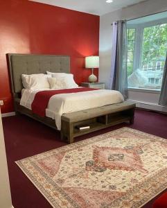 1 dormitorio con 1 cama grande y pared roja en Room at The Oasis, en Brooklyn