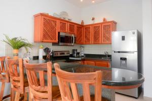 a kitchen with a table with chairs and a refrigerator at Delluz Bahia Azul 4B Pool view, Jaco Beach 2nd floor in Jacó