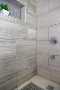 a bathroom with a shower with a stone wall at Sweet Kensville @ New Kingston in Kingston