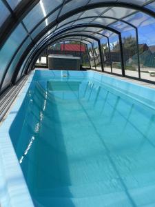 une grande piscine d'eau bleu clair dans l'établissement OSADA JANTAR, à Jantar