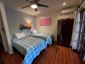 - une chambre avec 2 lits et un ventilateur de plafond dans l'établissement The Mermaid and The Pearl Boutique B&B, à Isla Mujeres