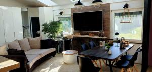 a living room with a couch and a table and a tv at ANTICA in Vrh nad Želimljami