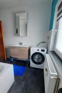 a bathroom with a washing machine and a sink at Hedys Apartment in Spiegelsberg