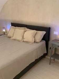 1 cama con almohadas blancas en una habitación con mesa en Salento Casa d’Angeli - App. 1, en Lecce