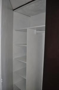 un armario con estanterías blancas en una habitación en Santa Ana Suites & Lofts, en Toluca