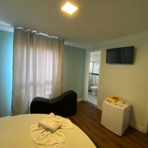 Zimmer mit einem Bett, einem TV und einem Bad in der Unterkunft Hotel Milenium Itapuã in Salvador
