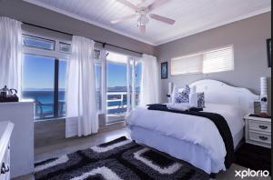 a bedroom with a bed with a view of the ocean at On the Rocks Guesthouse in Gansbaai