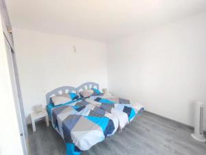 a bedroom with a bed with a blue and white comforter at sakina parque paraiso in Parque Holandes +16 photos