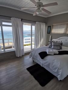 a bedroom with a bed with a view of the ocean at On the Rocks Guesthouse in Gansbaai